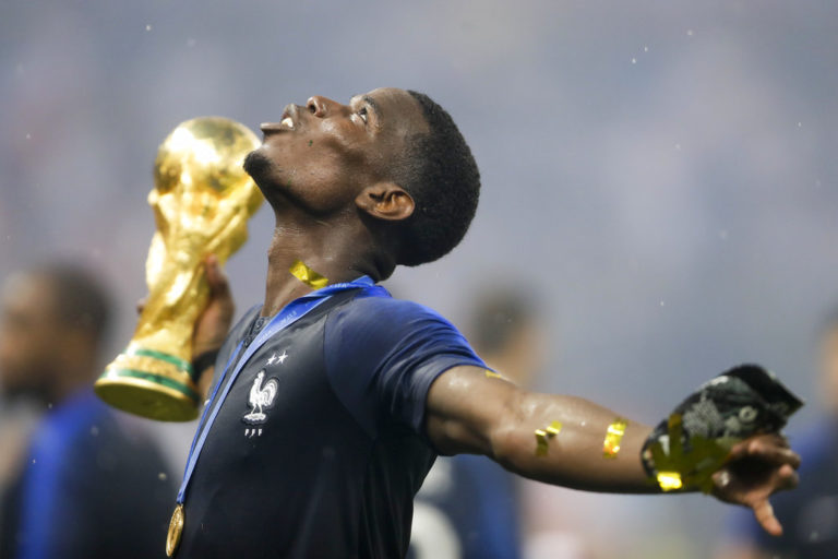 El francés Paul Pogba festeja con el trofeo tras la victoria de Francia por 4-2 ante Croacia. El jugador tiene ascendencia de Guinea, pero nació hace 25 años en Lagny-sur-Marne, Francia. (AP Foto/Natacha Pisarenko)