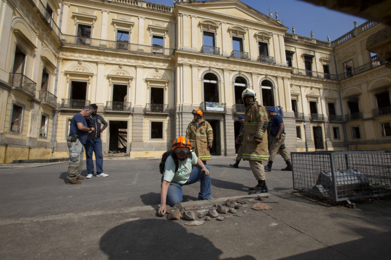 Un trabajador del Museo Nacional de Brasil organiza las piezas rescatadas del museo un día después de un devastador incendio, el lunes 3 de septiembre de 2018, en Río de Janeiro. (AP Foto/Silvia Izquierdo)