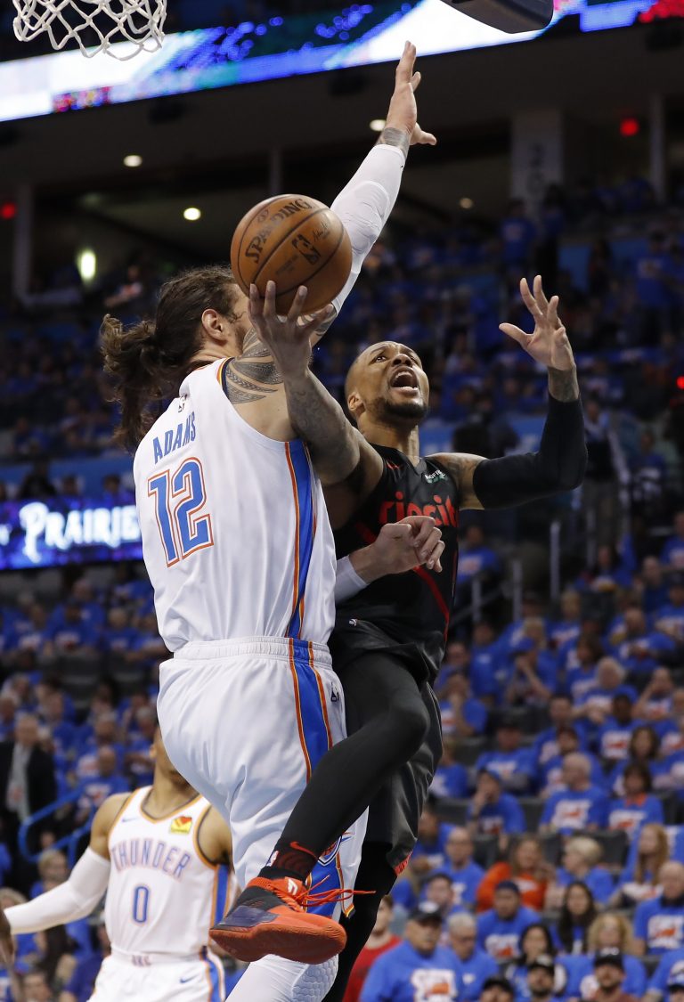 AP Photo,El jugador de los Trail Blazers de Portland Damian Lillard (0) tira a canasta mientras el jugador del Thunder de Oklahoma City Steven Adams (12) defiende en la segunda mitad del cuarto partido de su serie de primer aornda de playoffs, el domingo 21 de abril de 2019 en Oklahoma City. Portland ganó 111-98. (AP Foto/Alonzo Adams)