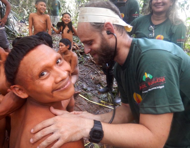 AP Photo,Esta foto del 2019 proporcionada por la Fundación Nacional para Asuntos Indígenas de Brasil, o FUNAI, muestra a un indígena Korubo sonriendo a la cámara mientras un miembro de la FUNAI lo ausculta durante una expedición al Valle Javari, en Brasil. (Fundación Nacional para Asuntos Indígenas de Brasil vía AP)
