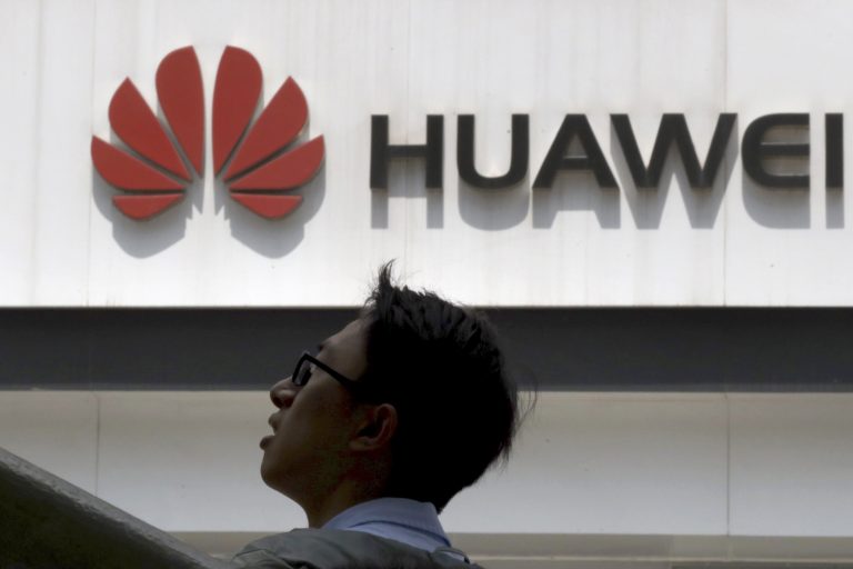 AP Photo,En esta imagen tomada el jueves 16 de mayo de 2019, un hombre pasa junto a una tienda Huawei en  Beijing. (AP Foto/Ng Han Guan)