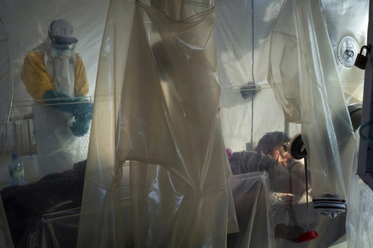AP Photo,En esta fotografía del sábado 13 de julio de 2019, trabajadores de salud con vestimenta protectora revisan a un paciente aislado en un pequeño cubículo hecho con plásticos en un centro de atención del ébola en Beni, República Democrática del Congo. (AP Foto/Jerome Delay)