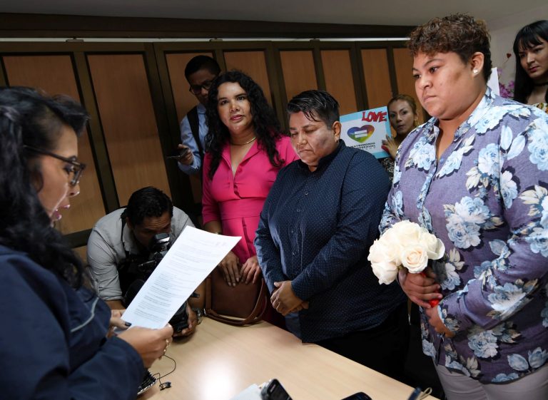 AP Photo,Michelle Avilés, a la derecha, y su pareja, Alexandra Chávez, en el centro, se casan en el Registro Civil de Guayaquil, Ecuador, el jueves 18 de julio de 2019. La pareja del mismo sexo se convirtió en la primera pareja gay en casarse en Ecuador después de una decisión reciente de la Corte Constitucional. (AP Foto )