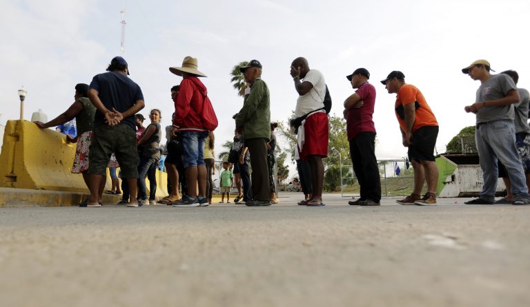 AP Photo,Personas que piden asilo en EEUU hacen cola para recibir comida de un grupo de voluntarios cerca del puente internacional de Matamoros, México, el 30 de abril del 2019. (AP Photo/Eric Gay, File)
