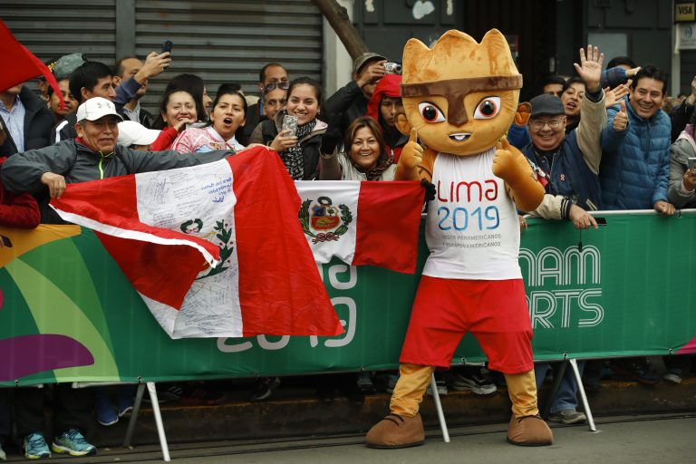 AP Photo,Milco, la mascota de los Juegos Panamericanos, festeja con un grupo de espetadores durante el maratón, el sábado 27 de julio de 2019 (AP Foto/Moisés Castillo)