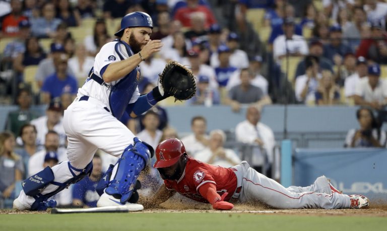 AP Photo, Luis Rengifo, Russell Martin,El jugador de los Angelinos de Los Ángeles Luis Rengifo (derecha), anota ante el catcher de los Dodgers de Los Ángeles Russell Martin en un sencillo de Shohei Ohtani en el segundo inning del juego de la MLB que enfrentó a ambos equipos, el 23 de julio de 2019, en Los Ángeles. (AP Foto/Marcio Jose Sanchez)