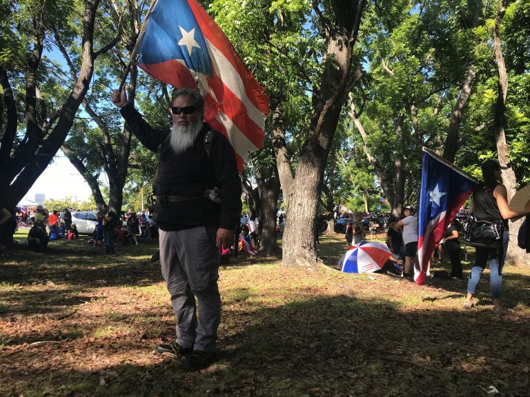 AP Photo,Germán Alejandro Ortiz, un empresario de 43 años de edad, sostiene una bandera de Puerto Rico durante una protesta para exigir la renuncia del gobernador Ricardo Rosselló, el lunes 22 de julio de 2019, en San Juan. (AP Foto/Danica Coto)