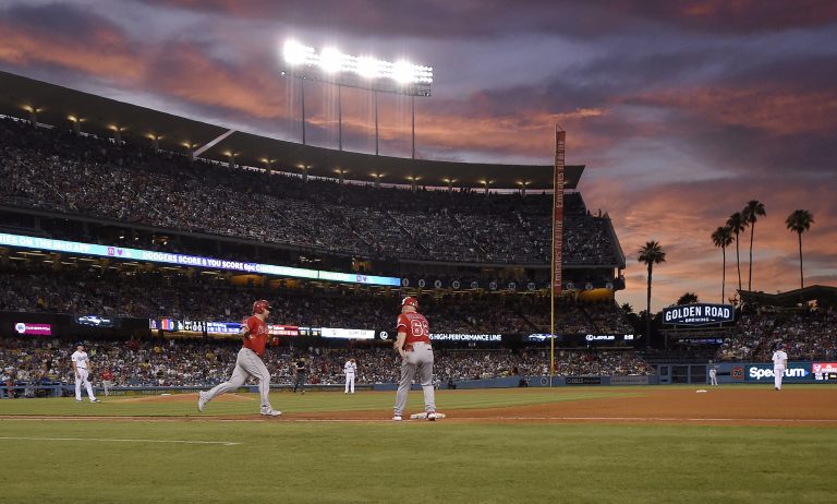 AP Photo, Kole Calhoun, Ross Stripling,El jugador de los Angelinos de Los Ángeles Kole Calhoun (segundo por la izquierda), llega a primera base tras disparar un jonrón solitario ante el abridor de los Dodgers, Ross Stripling (izquierda), en el cuarto inning del juego de la MLB que enfrentó a ambos equipos, el 24 de julio de 2019, en Los Ángeles. (AP Photo/Mark J. Terrill)