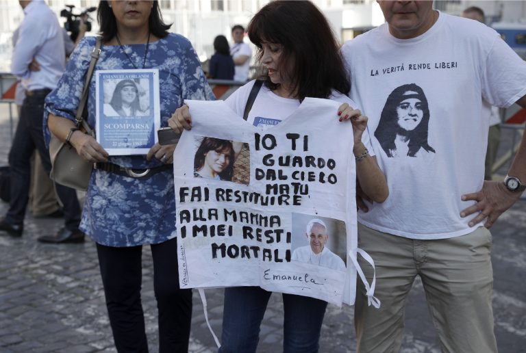 AP Photo,Reanta Grattani, quien dice ser amiga de la familia Orlandi, centro, sostiene una camiseta con fotos de Emanuela Orlandi y el papa Francisco y un mensaje que lee: 