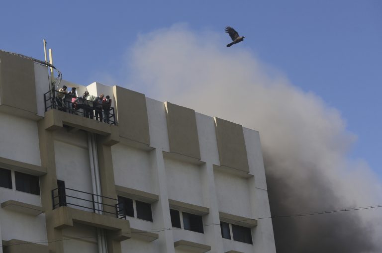 AP Photo,Unas personas esperan a ser rescatadas en un edificio de nueve pisos que se incendió en Mumbai, India, el lunes 22 de julio de 2019. (AP Foto/Rafiq Maqbool)