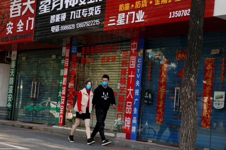 LYNXMPEG1G0VF.jpg,FOTO DE ARCHIVO. Personas con mascarillas caminan frente a tiendas cerradas debido al brote de coronavirus, en Jiujiang, China. 4 de febrero de 2020. REUTERS/Thomas Peter.; Crédito: THOMAS PETER, Reuters