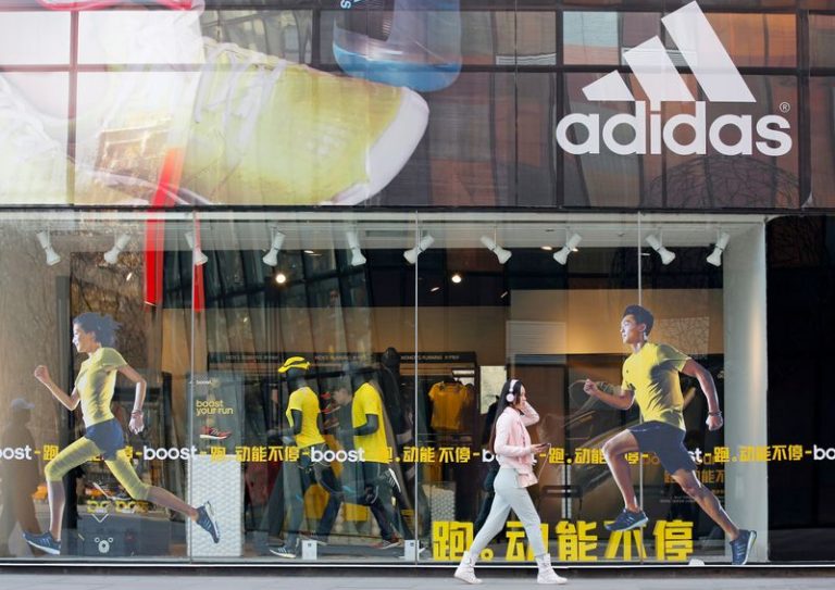 LYNXMPEG1I118.jpg,FOTO DE ARCHIVO. Una mujer pasa junto a una tienda de Adidas en un distrito comercial de Pekín, en China. 25 de marzo de 2013. REUTERS/Kim Kyung-hoon.; Crédito: KIM KYUNG-HOON, Reuters
